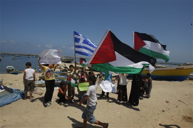 Palestinian children hold Palestinian and Greek flags as they protest in support of the Gaza-bound flotilla in the port of Gaza City, on Sunday. Greek authorities have arrested the captain of a boat that is part of a Gaza-bound flotilla trying to deliver humanitarian aid to the Palestinian territory, officials said Saturday. 